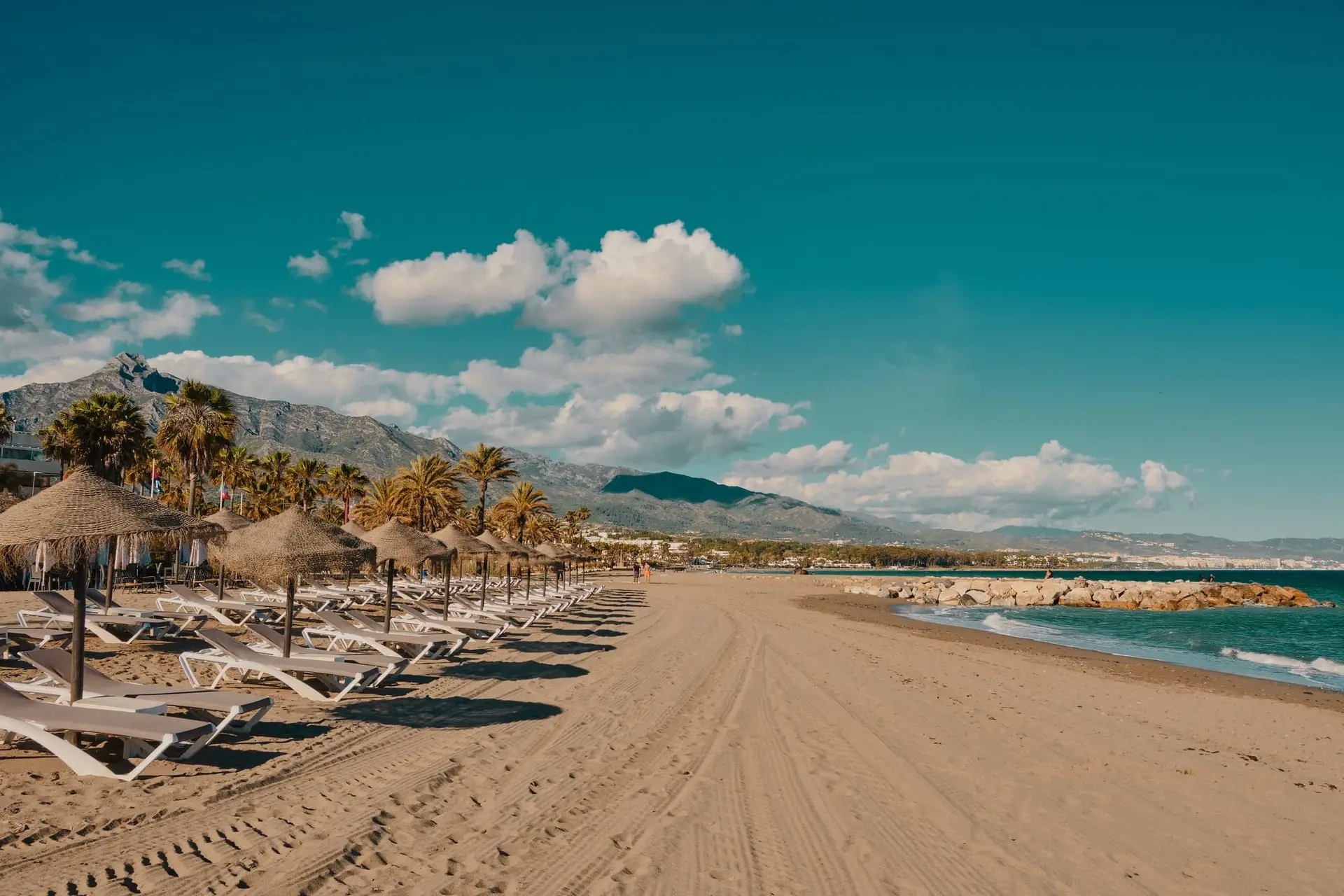 A breathtaking view of Puerto Banús Marina in Marbella, Spain, with luxury yachts and blue skies—an ideal destination for expats and travelers.