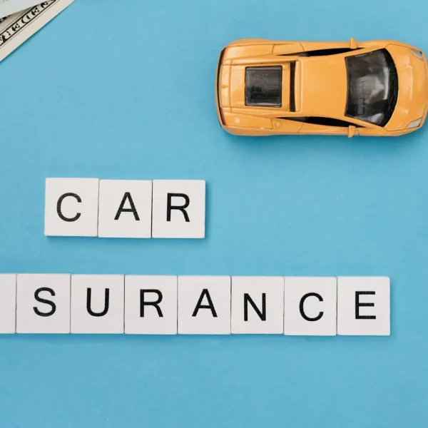 Car Insurance Protection – Secure Your Ride Today Wooden blocks spelling “Car Insurance” next to a sleek yellow Lamborghini, symbolizing vehicle protection and financial security.